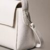 Bolso de hombro con herrajes con el logotipo del emblema