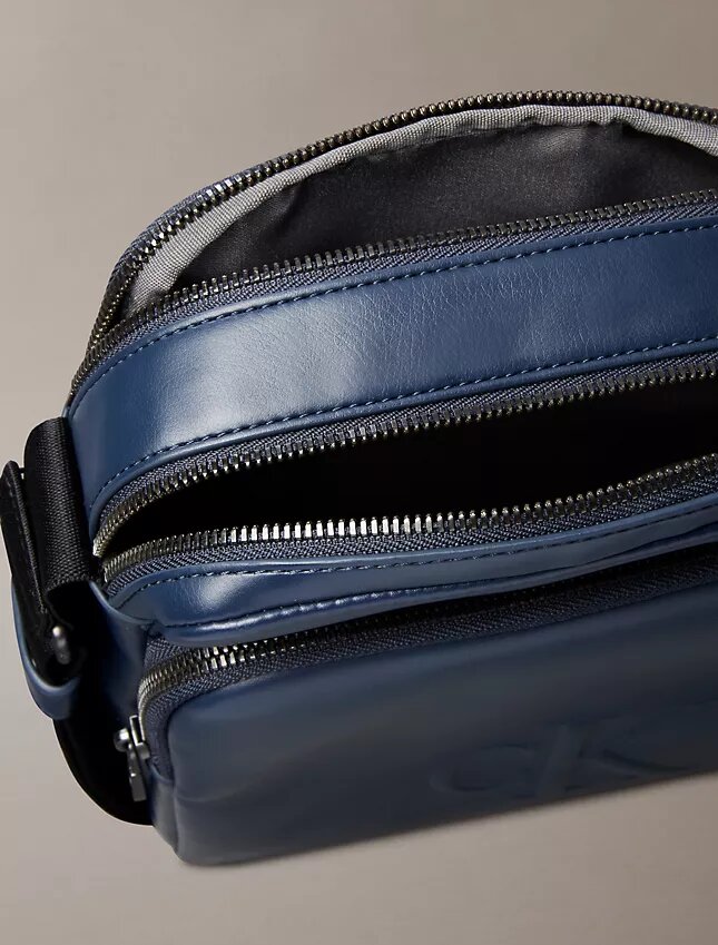 Bolso tipo reporter con bolsillo con cremallera y Monogram en relieve Bolso tipo reporter con bolsillo con cremallera y Monogram en relieve