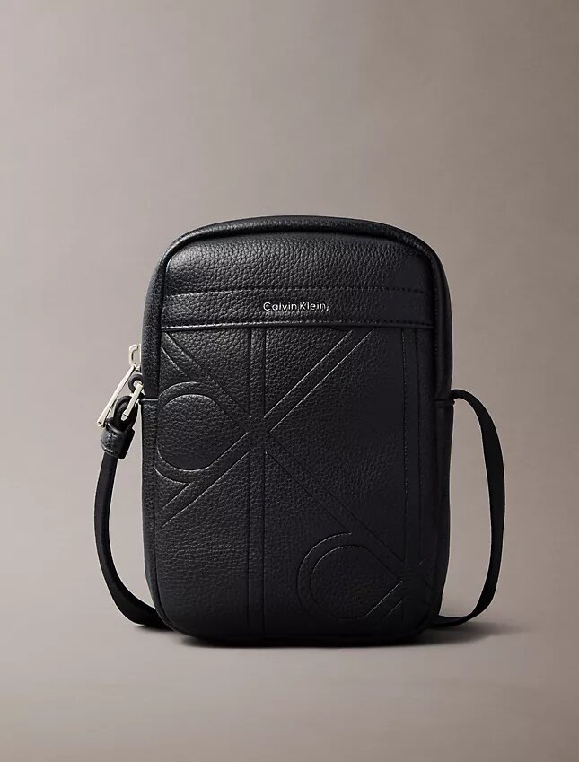 Bolso tipo reporter delgado con el logotipo del emblema grabado en toda la superficie Bolso tipo reporter delgado con el logotipo del emblema grabado en toda la superficie