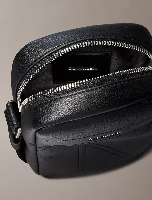 Bolso tipo reporter delgado con el logotipo del emblema grabado en toda la superficie Bolso tipo reporter delgado con el logotipo del emblema grabado en toda la superficie
