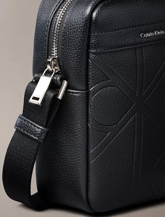 Bolso tipo reporter delgado con el logotipo del emblema grabado en toda la superficie Bolso tipo reporter delgado con el logotipo del emblema grabado en toda la superficie