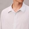 Camisa de rayas con botones, confeccionada en mezcla de viscosa y corte relajado Camisa de rayas con botones, confeccionada en mezcla de viscosa y corte relajado