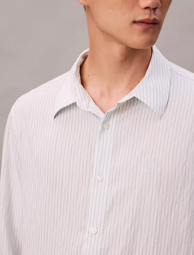 Camisa de rayas con botones, confeccionada en mezcla de viscosa y corte relajado Camisa de rayas con botones, confeccionada en mezcla de viscosa y corte relajado