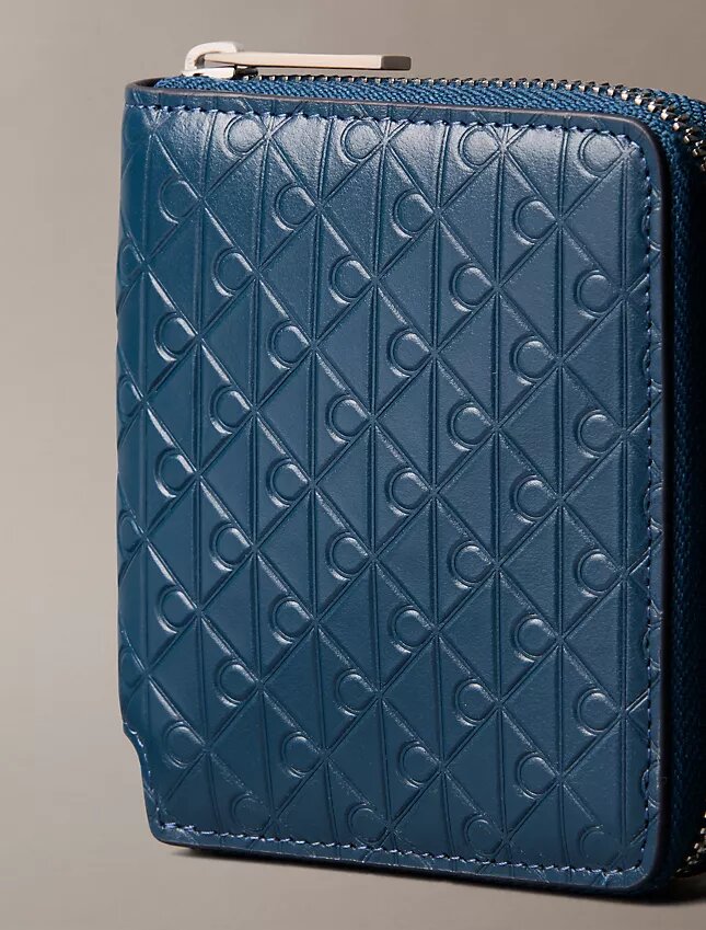 Cartera con cremallera y logotipo en relieve por toda la superficie Cartera con cremallera y logotipo en relieve por toda la superficie