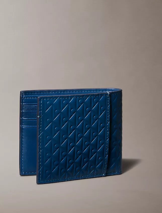 Cartera doble con Monogram en relieve en toda la superficie y bolsillo para monedas Cartera doble con Monogram en relieve en toda la superficie y bolsillo para monedas